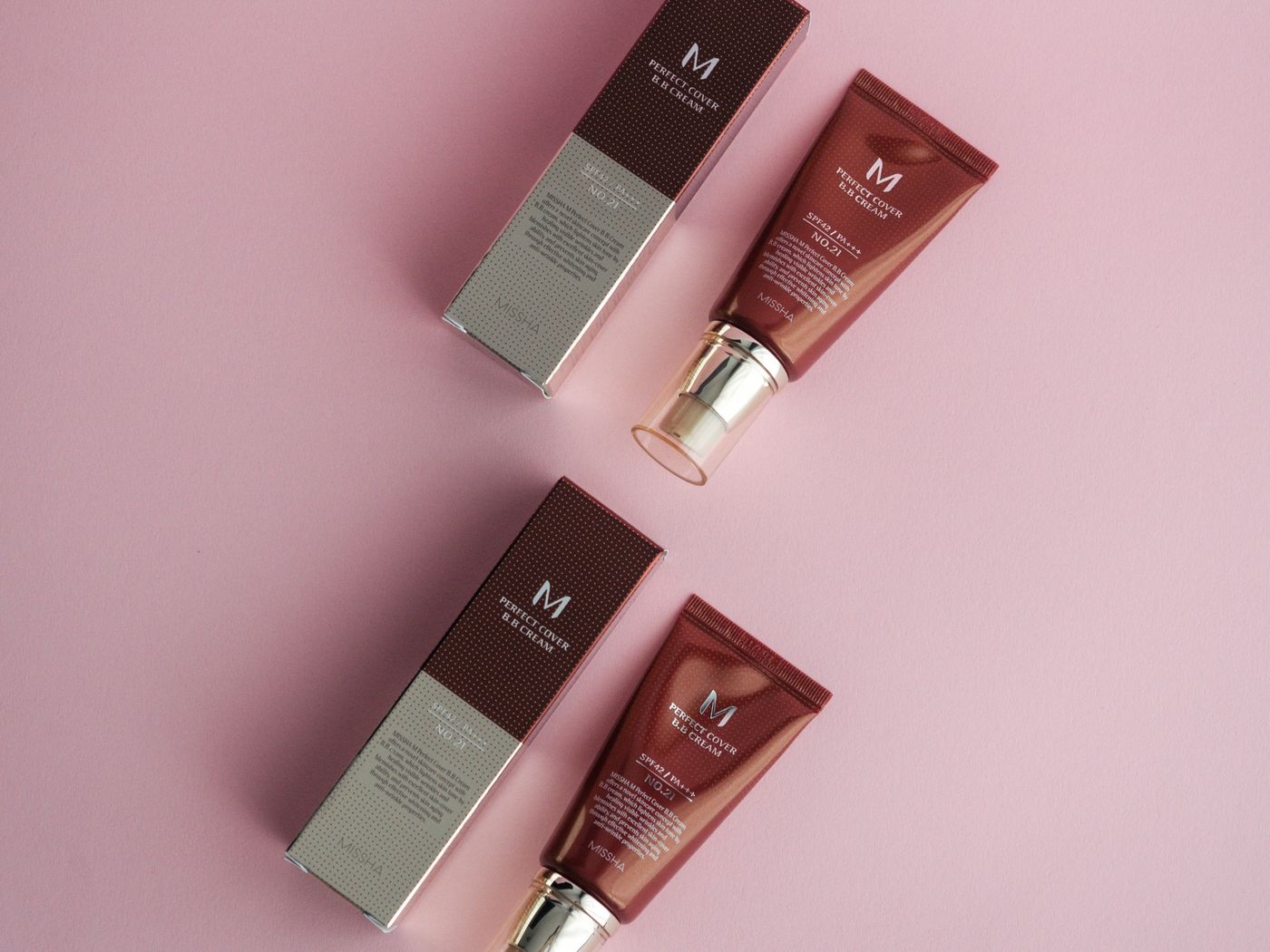 MISSHA cosmetic tubes and packaging on a pink surface